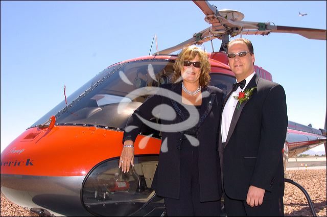 A couple standing in front of a helicopter