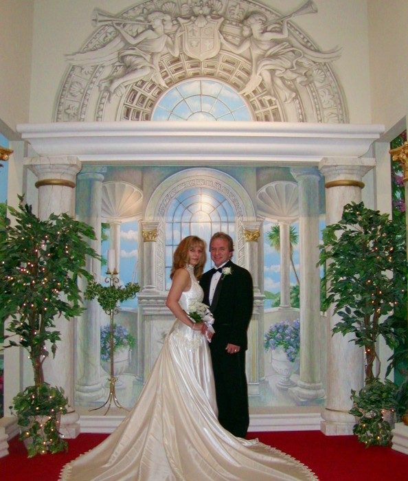 A couple at the altar with a cascading satin train